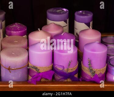 Set aus Lavendel-, lila oder violetten Kerzen, handgefertigt und auf einem Holztablett platziert Stockfoto
