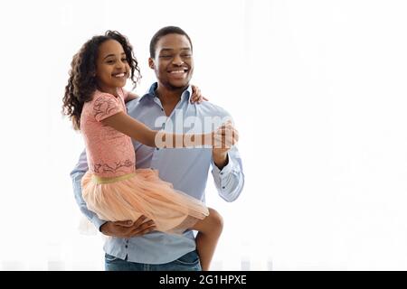 Fröhlicher afroamerikanischer Vater und Kind tanzen auf Weiß Stockfoto