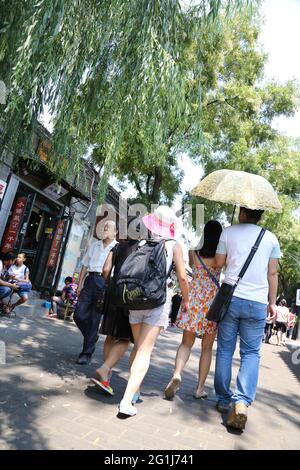 Händler und Touristen mischen sich auf dem Nanluogu Xiang des Bezirks Dongcheng in Peking, Volksrepublik China. Stockfoto