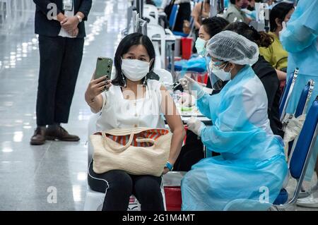 Eine Frau macht ein Selfie, während sie während einer Massenimpfung gegen COVID-19 in der Bang Sue Grand Station in Bangkok mit einer Dosis AstraZeneca-Impfstoff verabreicht wird. Thailand begann mit einer Massenimpfung gegen die COVID-19-Coronavirus-Pandemie im ganzen Land, um die landesweite Ausbreitung der COVID-19-Coronavirus-Pandemie ab dem 7. Juni 2021 einzudämmen. (Foto von Peerapon Boonyakiat / SOPA Image/Sipa USA) Stockfoto