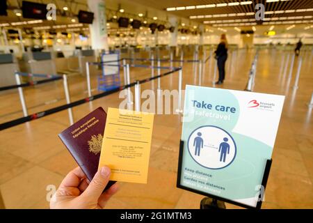 Belgien, Brüssel, Flughafen Zaventem, 26. Februar 2021: Französischer Reisender mit seinem Reisepass und einem Internationalen Impfzertifikat oder Prophylax Stockfoto