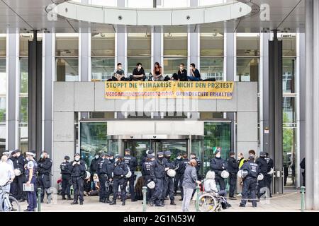 Düsseldorf, Deutschland. Juni 2021. Umweltaktivisten der Gruppe Extinction Rebellion protestieren vor dem Haupteingang des NRW-Innenministeriums. Die Demonstranten setzten sich vor dem Eingang in ein Sit-in und kletterten auf das Dach des Eingangsportals, wo sie ein Banner enthüllten: "Stoppt die Klimakrise, nicht den Protest". Quelle: Marcel Kusch/dpa/Alamy Live News Stockfoto