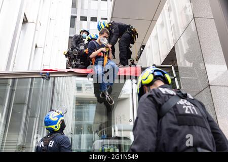 Düsseldorf, Deutschland. Juni 2021. Ein Umweltaktivist der Gruppe Extinction Rebellion wird vom Haupteingang des NRW-Innenministeriums abgespreizt. Die Demonstranten hatten sich vor dem Eingang auf ein Sit-in gesetzt und kletterten auf das Dach des Eingangsportals, wo sie ein Banner enthüllten: „Stoppen Sie die Klimakrise, nicht den Protest“. Quelle: Marcel Kusch/dpa/Alamy Live News Stockfoto