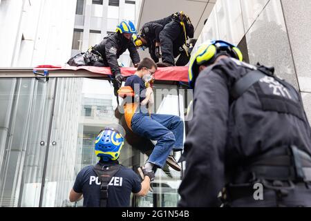 Düsseldorf, Deutschland. Juni 2021. Ein Umweltaktivist der Gruppe Extinction Rebellion wird vom Haupteingang des NRW-Innenministeriums abgespreizt. Die Demonstranten hatten sich vor dem Eingang auf ein Sit-in gesetzt und kletterten auf das Dach des Eingangsportals, wo sie ein Banner enthüllten: „Stoppen Sie die Klimakrise, nicht den Protest“. Quelle: Marcel Kusch/dpa/Alamy Live News Stockfoto