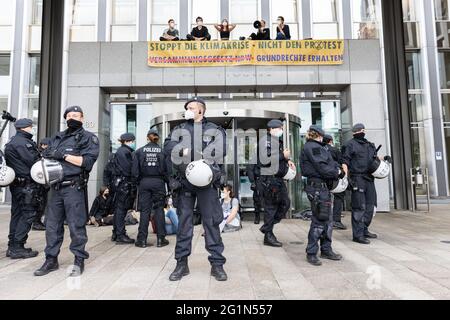 Düsseldorf, Deutschland. Juni 2021. Umweltaktivisten der Gruppe Extinction Rebellion protestieren vor dem Haupteingang des NRW-Innenministeriums. Die Demonstranten setzten sich vor dem Eingang in ein Sit-in und kletterten auf das Dach des Eingangsportals, wo sie ein Banner enthüllten: "Stoppt die Klimakrise, nicht den Protest". Quelle: Marcel Kusch/dpa/Alamy Live News Stockfoto