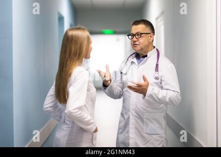 Ärzte im Gesundheitswesen, die im Krankenhausflur diskutieren Stockfoto