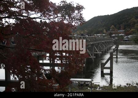 KYOTO, JAPAN - Dec 11, 2019: Kyoto, Japan-26 Nov, 2019: Togetsu-kyo Brücke über Katsuragawa Fluss mit buntem Waldberg Hintergrund in Arashiy Stockfoto