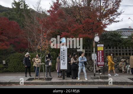 KYOTO, JAPAN - 11. Dez 2019: Kyoto, Japan-26. Nov 2019: Menschen warten auf den Stadtbus in Arashiyama, Kyoto. Die Busse der Stadt Kyoto sind der Hauptmittelst der Publ Stockfoto