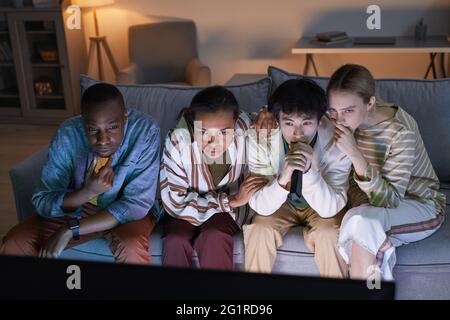 Mit blauem Licht können Sie aus einem großen Blickwinkel verschiedene Freunde beobachten, die zu Hause Fernsehen Stockfoto