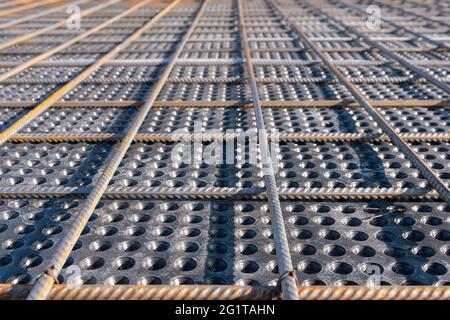 Nahaufnahme der Betonbewehrung. Geometrische Ausrichtung der Resten auf der Baustelle. Verstärkungen Stahlstäbe stapeln. Stockfoto