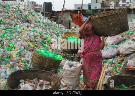 Dhaka, Bangladesch. Juni 2021. Eine Arbeiterin sortiert Plastikflaschen in einer Kunststoff-Recycling-Fabrik in Dhaka, Bangladesch. Sie erhält 1.5-2 US-Dollar pro Tag für ihre Arbeit. Das Recycling von Kunststoffflaschen hat sich in den letzten Jahren zu einem wachsenden Geschäft entwickelt und trägt zum Schutz der Umwelt bei. Quelle: Abu Sufian Jewel/ZUMA Wire/Alamy Live News Stockfoto