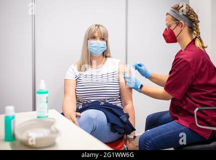 Hannover, Deutschland. Juni 2021. Janina Müller, eine Angestellte der Versicherungsgesellschaft, erhält ihre erste Corona-Impfung mit dem BioNTech/Pfizer-Impfstoff von einer Krankenpflegerin. Eine Impfinitiative der Hannoveraner Versicherer startete mit Corona-Impfungen. Eingeladen waren Mitarbeiter aus neun Versicherungsgruppen. Quelle: Moritz Frankenberg/dpa/Alamy Live News Stockfoto