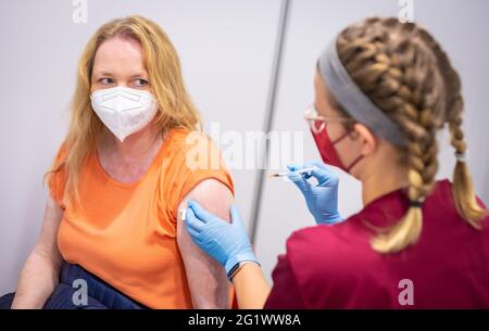 Hannover, Deutschland. Juni 2021. Eine Mitarbeiterin einer Versicherungsgesellschaft erhält ihre erste Corona-Impfung mit dem BioNTech/Pfizer-Impfstoff von einem Mitarbeiter im Gesundheitswesen. Eine Impfinitiative der Hannoveraner Versicherer startete mit Corona-Impfungen. Eingeladen waren Mitarbeiter aus neun Versicherungsgruppen. Quelle: Moritz Frankenberg/dpa/Alamy Live News Stockfoto