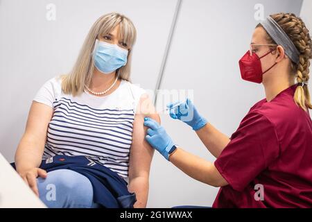 Hannover, Deutschland. Juni 2021. Janina Müller, eine Angestellte der Versicherungsgesellschaft, erhält ihre erste Corona-Impfung mit dem BioNTech/Pfizer-Impfstoff von einer Krankenpflegerin. Eine Impfinitiative der Hannoveraner Versicherer startete mit Corona-Impfungen. Eingeladen waren Mitarbeiter aus neun Versicherungsgruppen. Quelle: Moritz Frankenberg/dpa/Alamy Live News Stockfoto