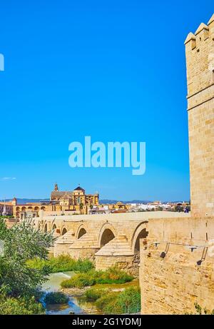 Der Blick auf die antike römische Steinbrücke und das monumentale Gebäude der Mezquita-Kathedrale (Moschee-Kathedrale) im Hintergrund, Cordoba, Spanien Stockfoto