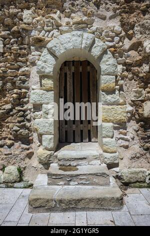 Alte gewölbte Steintür in der Wand der Abteikirche Saint Pierre, Beaulieu-lès-Loches, Indre-et-Loire (37), Frankreich. Stockfoto