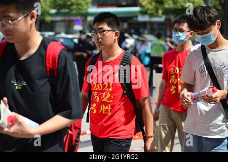 Stadt Fuyang, China. Juni 2021. Schüler, die in roten T-Shirts gekleidet sind, sehen, wie sie in den Testraum gehen, um sich auf die Matheprüfung im Prüfungszentrum der Mittelschule Nr. 2 von Fuyang vorzubereiten. Die Aufnahmeprüfung für die chinesische Hochschule begann 2021. In diesem Jahr haben sich 10.78 Millionen Menschen für die Aufnahmeprüfung der nationalen Hochschule angemeldet, ein Rekordhoch. Kredit: SOPA Images Limited/Alamy Live Nachrichten Stockfoto