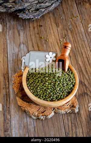 Bambusschüssel mit grünen Azuki-Bohnen auf Holztisch Stockfoto