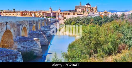 Das berühmte Stadtbild von Cordoba mit der antiken römischen Kalksteinbrücke, dem Grün am Guadalquivir-Fluss, der atemberaubenden Mezquita, dem Tor Puerta del Puente und Episcopal Stockfoto