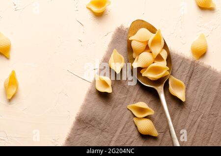 Abissine rigate Pasta in einem Löffel mit einer beigen Serviette, auf einem hellen Hintergrund. Stockfoto