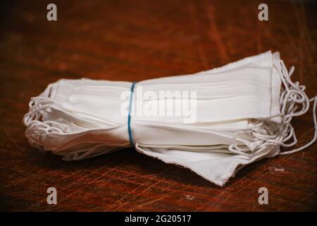 Ein Stapel medizinischer Schutzmasken auf einem zerkratzten Holz Tabelle Stockfoto