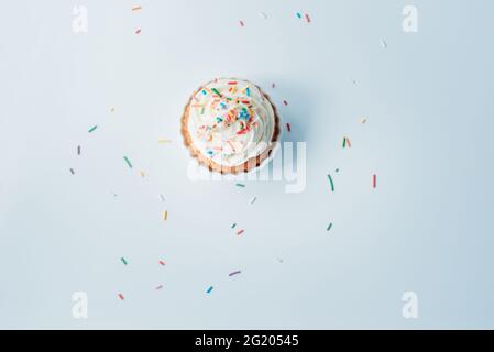 Hausgemachter Cupcake mit bunten Streuseln auf weißem Hintergrund. Stockfoto