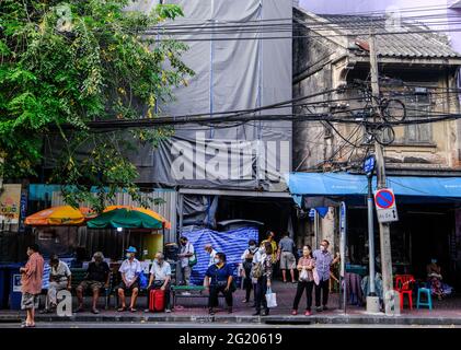 Die Menschen warten auf einen Bus auf der Charoen Krung Road, Chinatown, Bangkok, Thailand Stockfoto