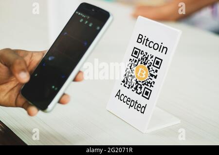 Nahaufnahme der Hände durch Handy Scannen Bitcoin QR-Code für digitalen Kontakt weniger Zahlung nach dem Einkauf mit Bitcoin Kryptowährung - Konzept Stockfoto