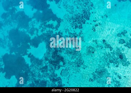 Meeresoberfläche türkis blau Farbe Hintergrund, Luftdrohne Draufsicht. Klares, geriffeltes Wasser, kleine Kykladen-Seestücke. Ägäische griechische Inseln Sommer vac Stockfoto