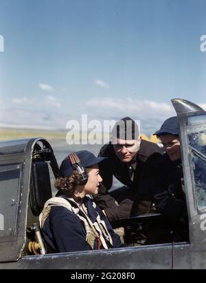Nicht identifizierte Wespen und ein männlicher Ausbilder, der sich unterhielt, bevor eine der weiblichen Piloten um 1944 zu einer Flugmission ohne Standort aufbricht. (Foto der US Army Air Force/RBM Vintage Images) Stockfoto