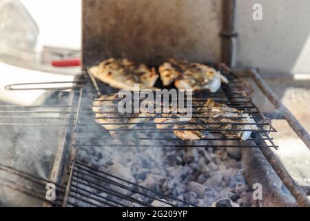 Köstlicher Seebarsch und goldener Fisch auf der Holzkohle in Portugal gegrillt Stockfoto