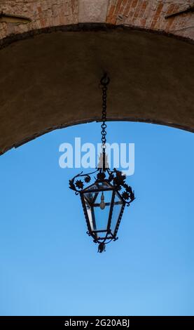 Eine Hängelampe in einem Torbogen in Lucca, Italien Stockfoto