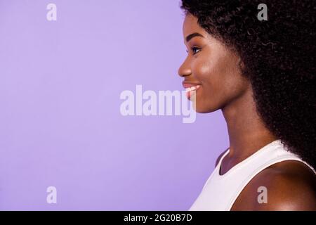 Cropped Profil Foto von entzückenden dunklen Haut Dame toothy Lächeln suchen leeren Raum isoliert auf violetten Hintergrund Stockfoto