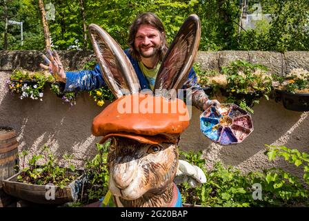 Der Künstler Chris Rutterford malt in seinem Außenstudio eine humorvolle riesige Fiberglas-Hase-Skulptur für einen Charity Art Trail, Schottland, Großbritannien Stockfoto