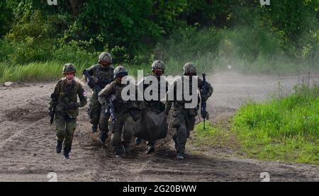 Münster, Deutschland. Juni 2021. Soldaten der Bundeswehr tragen bei einer Kampfdemonstration einen "Verwundeten". Quelle: Philipp Schulze/dpa/Alamy Live News Stockfoto