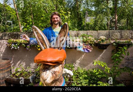 Der Künstler Chris Rutterford malt in seinem Außenstudio eine humorvolle riesige Fiberglas-Hase-Skulptur für einen Charity Art Trail, Schottland, Großbritannien Stockfoto