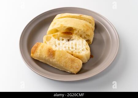 Frisch gebackenes Ciabatta-Brot wird auf einen Teller gelegt Stockfoto