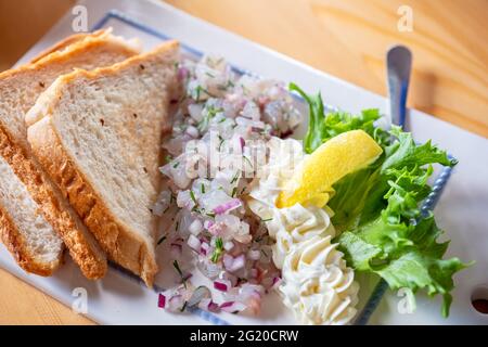 Zander-Tartare mit Zwiebel und Brottoast Stockfoto