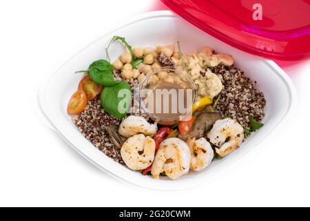 Salat mit Garnelen, warmem gegrilltem Gemüse, Quinoa, Kichererbsen, Tomaten und Hummus. Essen zum Mitnehmen. Ausgewogenes Mittagessen. Stockfoto