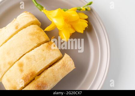 Frisch gebackenes Ciabatta-Brot wird auf einen Teller gelegt Stockfoto
