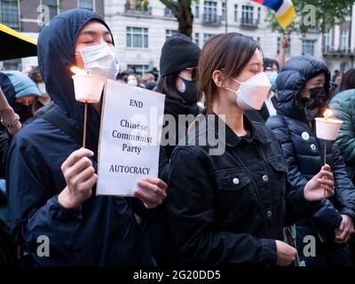 Maskierte Demonstranten versammeln sich mit Kerzen vor der chinesischen Botschaft in London, Großbritannien, zum 32. Jahrestag des Massakers vom 4. Juni auf dem Platz des Himmlischen Friedens in China. Stockfoto