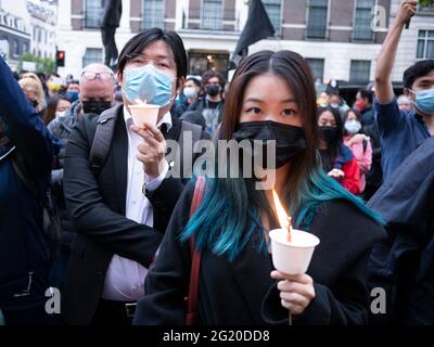 Maskierte Demonstranten versammeln sich mit Kerzen vor der chinesischen Botschaft in London, Großbritannien, zum 32. Jahrestag des Massakers vom 4. Juni auf dem Platz des Himmlischen Friedens in China. Stockfoto