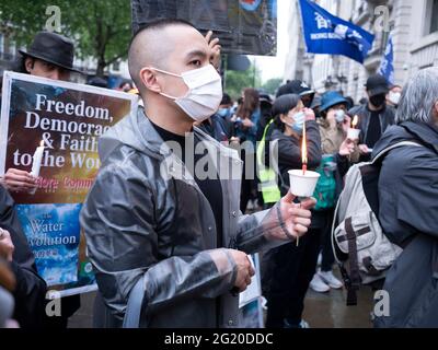 Maskierte Demonstranten versammeln sich mit Kerzen vor der chinesischen Botschaft in London, Großbritannien, zum 32. Jahrestag des Massakers vom 4. Juni auf dem Platz des Himmlischen Friedens in China. Stockfoto