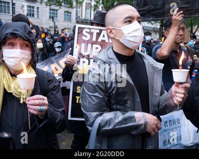 Maskierte Demonstranten versammeln sich mit Kerzen vor der chinesischen Botschaft in London, Großbritannien, zum 32. Jahrestag des Massakers vom 4. Juni auf dem Platz des Himmlischen Friedens in China. Stockfoto