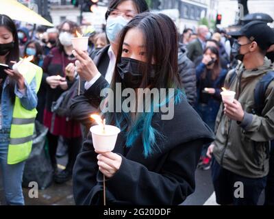 Maskierte Demonstranten versammeln sich mit Kerzen vor der chinesischen Botschaft in London, Großbritannien, zum 32. Jahrestag des Massakers vom 4. Juni auf dem Platz des Himmlischen Friedens in China. Stockfoto