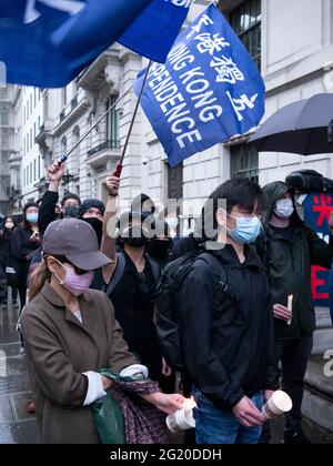 Maskierte Demonstranten versammeln sich mit Kerzen vor der chinesischen Botschaft in London, Großbritannien, zum 32. Jahrestag des Massakers vom 4. Juni auf dem Platz des Himmlischen Friedens in China. Stockfoto