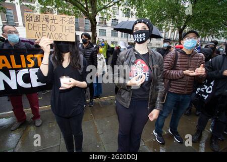 Maskierte Demonstranten versammeln sich mit Kerzen vor der chinesischen Botschaft in London, Großbritannien, zum 32. Jahrestag des Massakers vom 4. Juni auf dem Platz des Himmlischen Friedens in China. Stockfoto