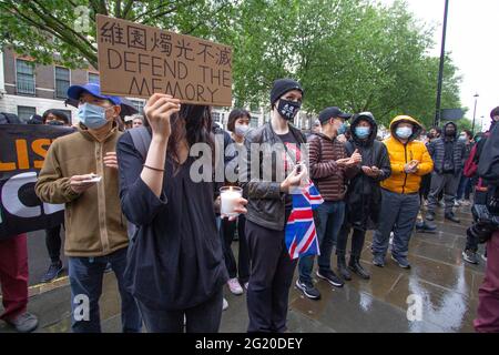 Maskierte Demonstranten versammeln sich mit Kerzen vor der chinesischen Botschaft in London, Großbritannien, zum 32. Jahrestag des Massakers vom 4. Juni auf dem Platz des Himmlischen Friedens in China. Stockfoto