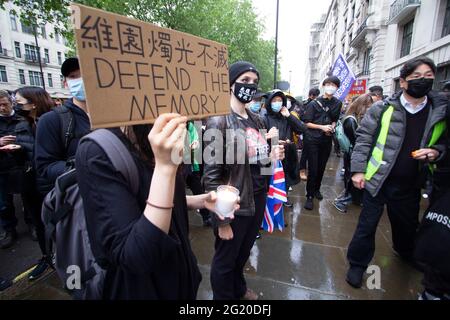 Maskierte Demonstranten versammeln sich mit Kerzen vor der chinesischen Botschaft in London, Großbritannien, zum 32. Jahrestag des Massakers vom 4. Juni auf dem Platz des Himmlischen Friedens in China. Stockfoto