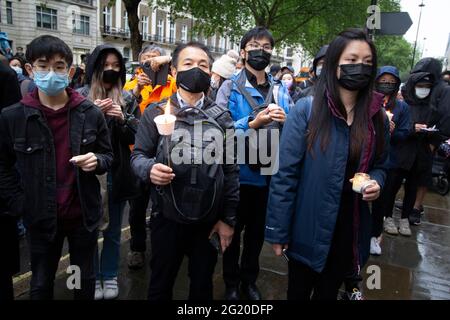 Maskierte Demonstranten versammeln sich mit Kerzen vor der chinesischen Botschaft in London, Großbritannien, zum 32. Jahrestag des Massakers vom 4. Juni auf dem Platz des Himmlischen Friedens in China. Stockfoto